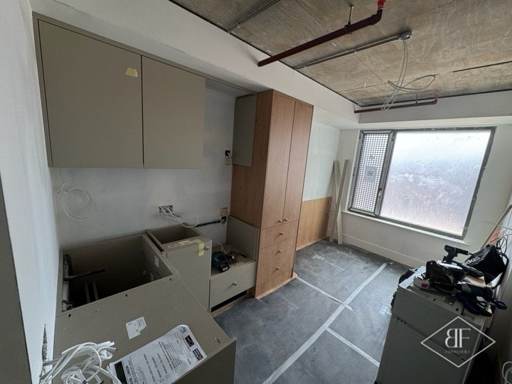Kitchen carcasses and wall units partly fitted, before worktop and appliances