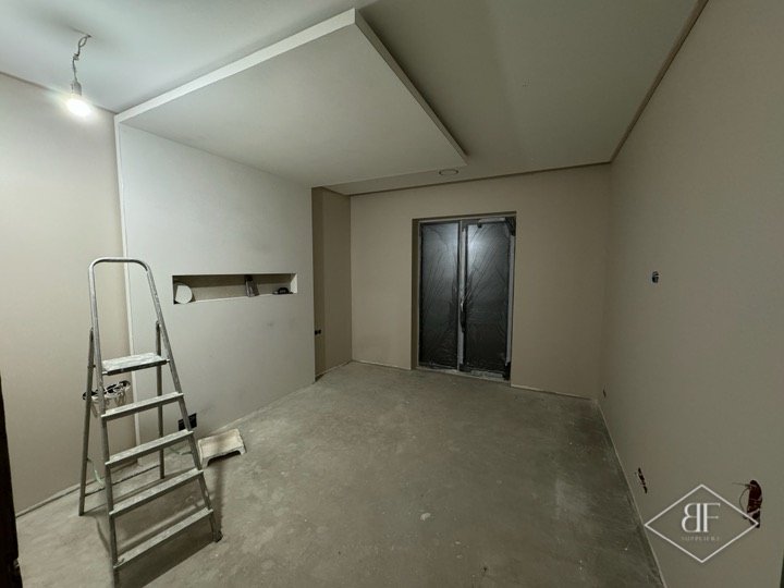 Plastered apartment room with stepped ceiling recess before lighting and feature wall installation