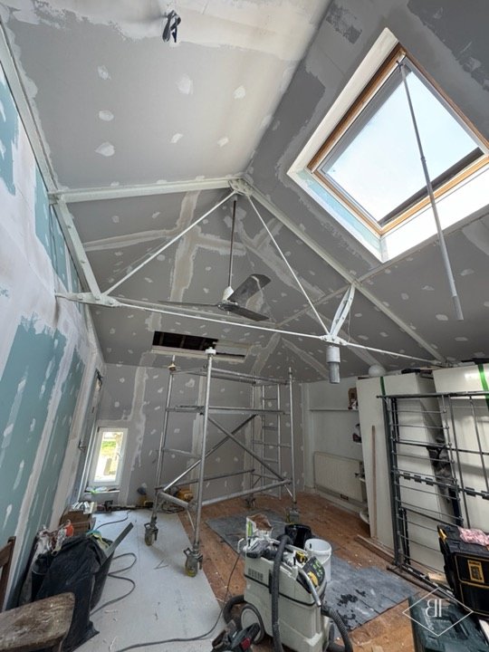 Loft room mid-works with plasterboard ceiling, rooflight and scaffold tower