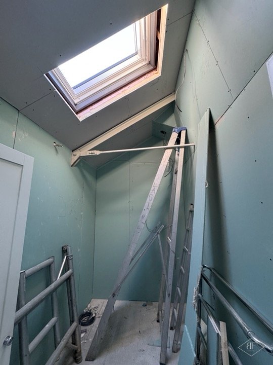 New plasterboard lining around a roof window, scaffold tower in place during works