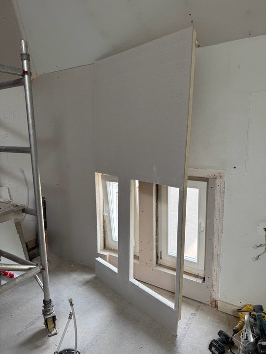 Scaffold tower beside new plasterboard and sash windows during the loft refurbishment