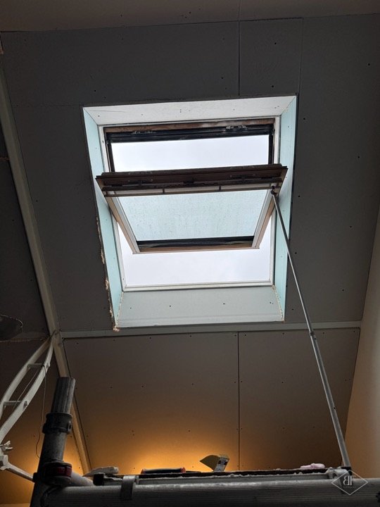 Looking up through a loft roof window with new lining and scaffold below