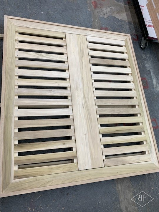 Slatted timber bed base frame laid flat in the workshop