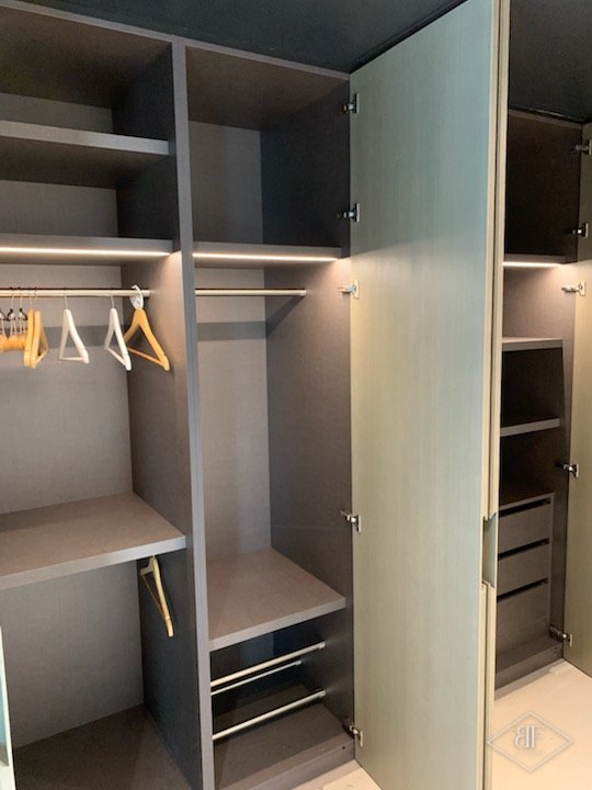 Fitted wardrobe interior with hanging rail, shelves and drawers, finished in grey veneer