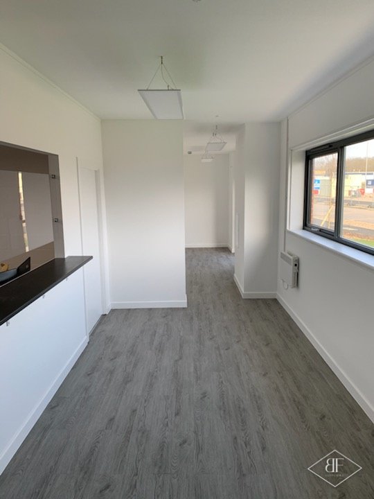 Hallway with wood-effect vinyl flooring and white reception counter