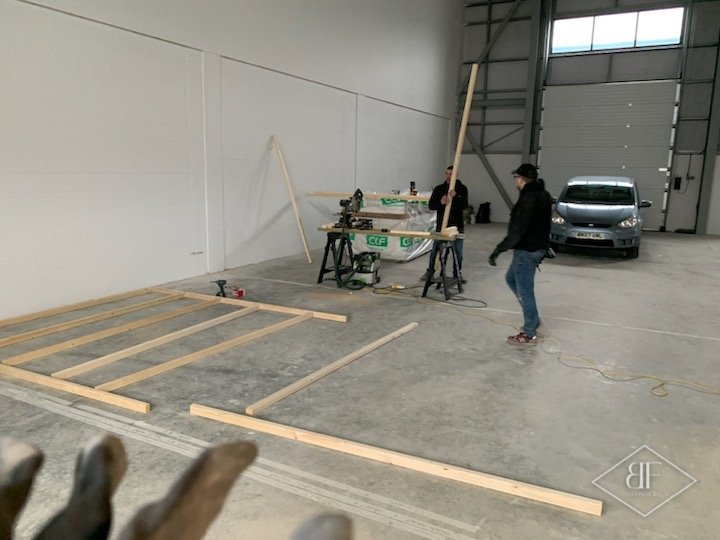 Timber floor plates marked out inside an industrial unit at the start of partition build