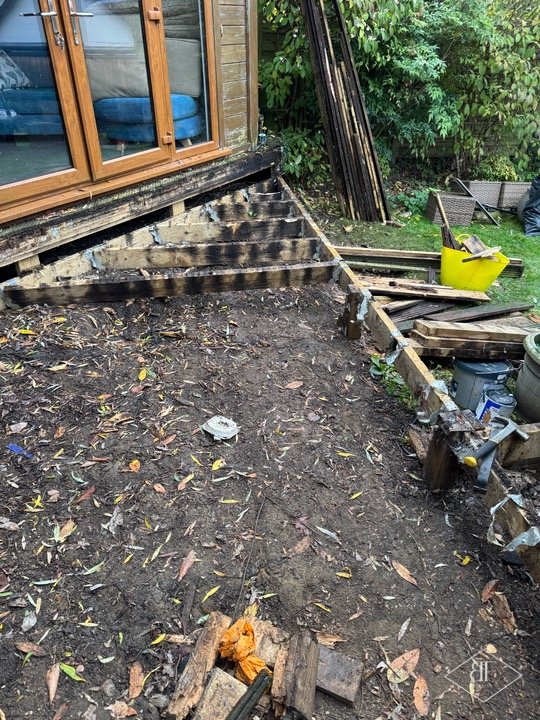Cleared garden decking base with joists ready for the replacement frame