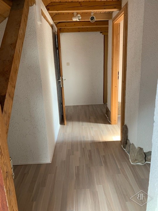 Narrow upstairs corridor with new light flooring and timber beams