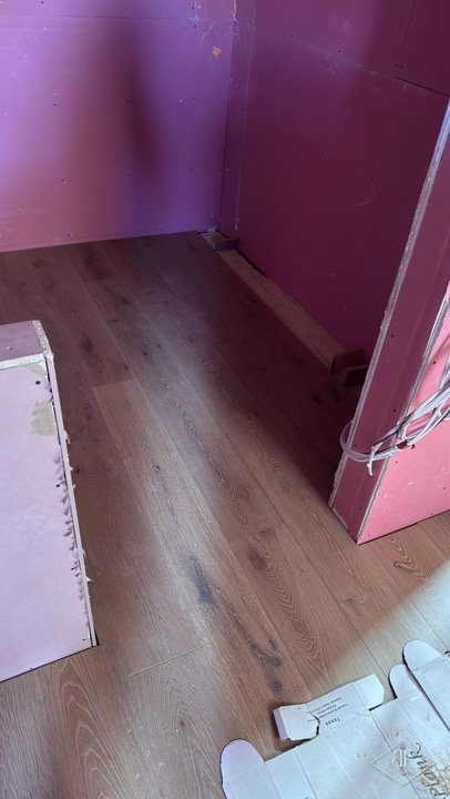 Timber flooring installed in a corner space with protected boarded walls
