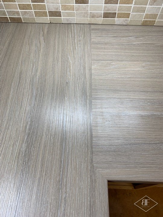 Pale plank flooring meeting a tiled area at a neat finished threshold