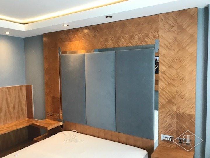 Chevron veneer headboard wall in a hotel suite