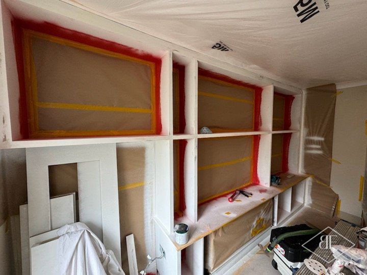 Shelving bays masked and sprayed red during decoration of the media wall