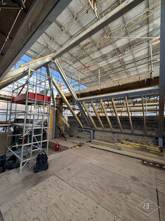 Roof void with plywood deck, scaffold tower and new rafters being fitted