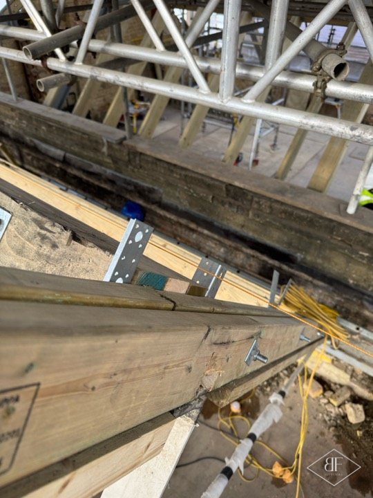 Metal bracket fixings joining new timber beams in the roof structure