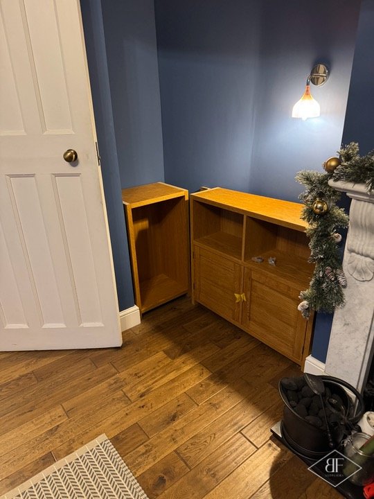 Pair of oak alcove units with worktop-style top beside a white panelled door