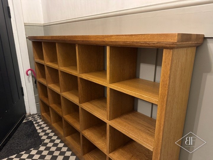 Bespoke oak shoe rack with square compartments in a tiled hallway, side view