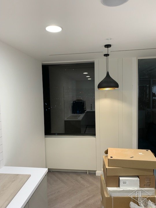 Freshly painted white wall panelling in a small office kitchen area