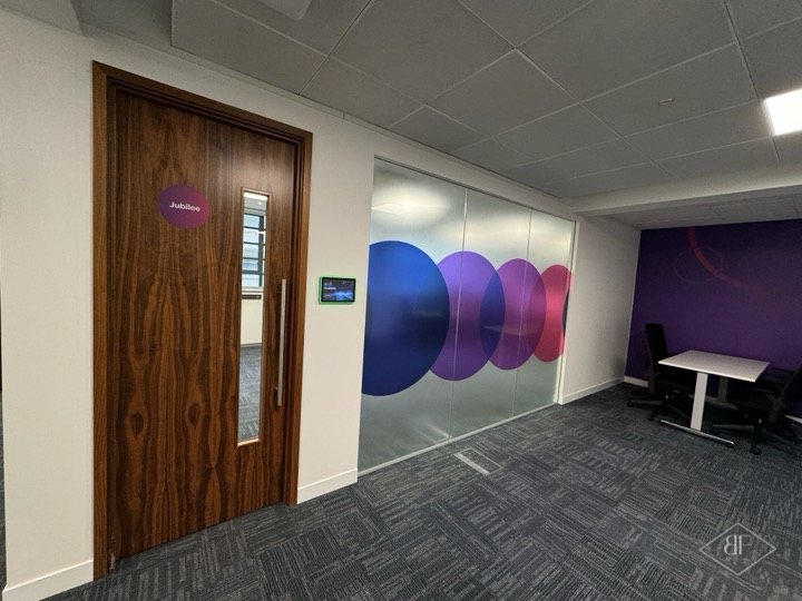 Walnut veneer door and glazed wall with purple circle graphics, finished