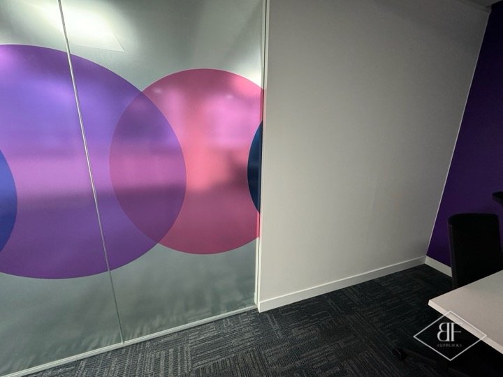 Frosted glass partition with large coloured circle film beside a new white wall