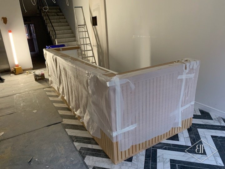 Slatted desk front protected with tape and film while the site is finished