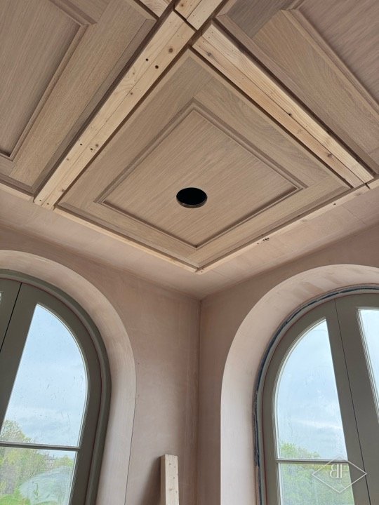 Single coffered ceiling bay with a round spotlight opening above two arched windows