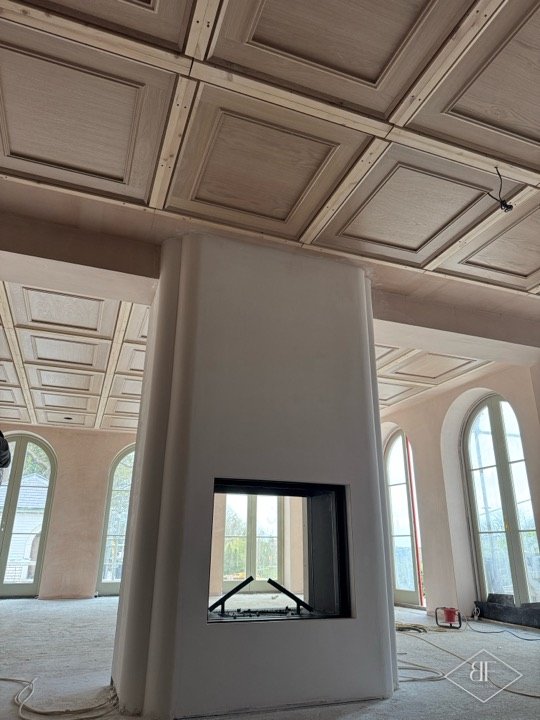 Central chimney breast with a through fireplace and oak coffered ceiling beyond, before finishing