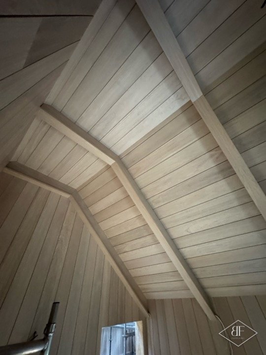 Oak boarded vaulted ceiling with exposed oak beams and angled panelling