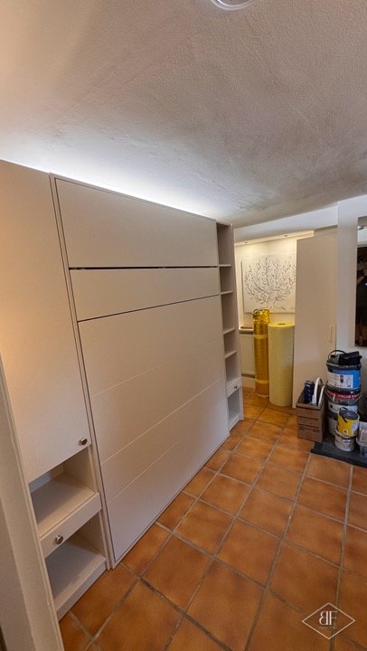Side view of the closed wall bed panel with soft lighting across the ceiling